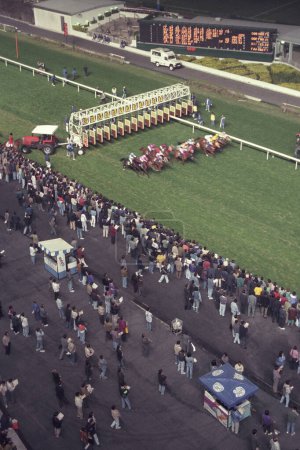 Téléchargez les photos : Une course de chevaux à l'hippodrome Happy Valley dans le centre de Hongkong dans la ville de Hongkong à Hongkong. Chine, Hongkong, mai 1997 - en image libre de droit
