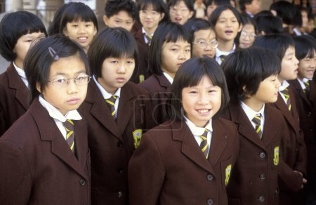 Photo for Scool children in uniform in Central in the city of Hongkong in the city of Hongkong in Hongkong.  China, Hongkong, May, 1999 - Royalty Free Image