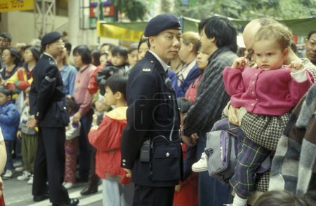Téléchargez les photos : La police de Hong Kong au travail à Tsim Sha Tsui à Kowloon dans la ville de Hongkong à Hongkong. Chine, Hongkong, février 1997 - en image libre de droit
