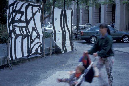 Téléchargez les photos : Les gens et les informations sur un mur, sur une marche de Démocratie en Chine avant la passation de Hongkong à la Chine dans la ville de Hongkong à Hongkong. Chine, Hongkong, Mai, 1997 - en image libre de droit