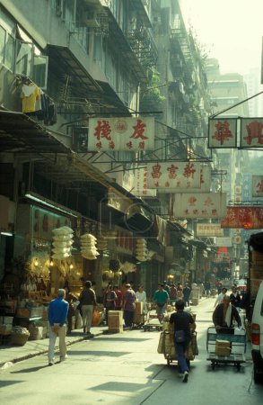 Téléchargez les photos : Personnes dans la rue commerçante dans la vieille ville de Kowloon dans la ville de Hongkong à Hongkong. Chine, Hongkong, décembre 1997 - en image libre de droit