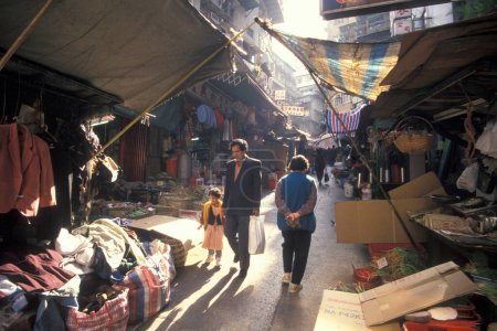 Téléchargez les photos : Personnes dans une rue commerçante dans la vieille ville de Kowloon dans la ville de Hongkong à Hongkong. Chine, Hongkong, décembre 1997 - en image libre de droit
