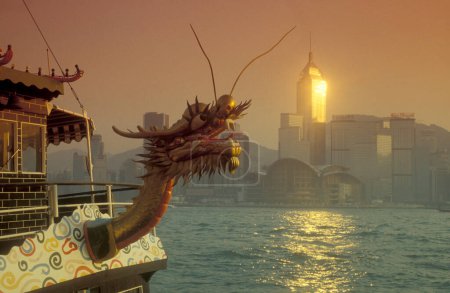 Foto de Un Dragonboat en el puerto de Victoria en frente del horizonte de Hongkong central desde el punto de vista de Kowloon en la ciudad de Hongkong en Hongkong. China, Hong Kong, mayo de 1999 - Imagen libre de derechos