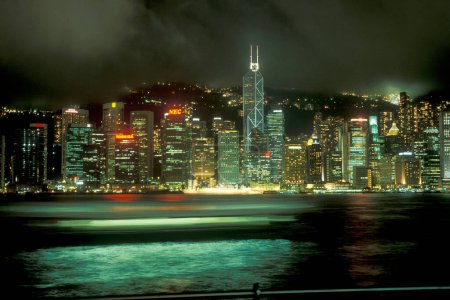 Foto de Una vista por la noche en el puerto de Victoria frente al horizonte de Hong Kong Central desde el punto de vista de Kowloon en la ciudad de Hong Kong en Hong Kong. China, Hong Kong, mayo de 1999 - Imagen libre de derechos