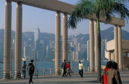 Téléchargez les photos : Personnes sur le port de Victoria en face de la Skyline de Hongkong centrale du point de vue de Kowloon dans la ville de Hongkong à Hongkong. Chine, Hongkong, mai 1999 - en image libre de droit