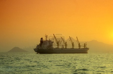 Téléchargez les photos : Un navire de fret sur la côte du centre de Hongkong du point de vue de Kowloon dans la ville de Hongkong à Hongkong. Chine, Hongkong, mai 1999 - en image libre de droit