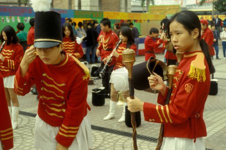 Photo for Young people in a traditional red British Royal Uniform on a Event in Kowloon in the city of Hongkong in Hongkong.  China, Hongkong, May, 1997 - Royalty Free Image