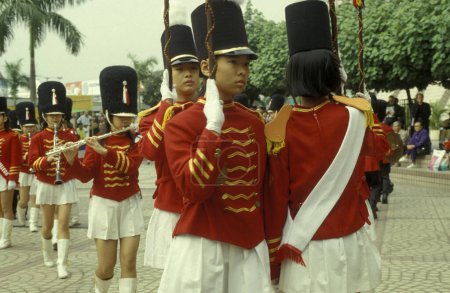 Téléchargez les photos : Jeunes dans un uniforme royal britannique rouge traditionnel lors d'un événement à Kowloon dans la ville de Hongkong à Hongkong. Chine, Hongkong, mai 1997 - en image libre de droit