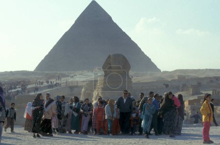 Téléchargez les photos : Touristes au monument de Sphinx en face des pyramides de giza près de la ville du Caire à la capitale de l'Egypte en Afrique du Nord. Égypte, Le Caire, mars 2000 - en image libre de droit