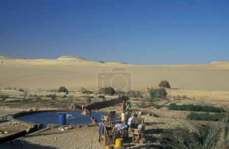 Téléchargez les photos : Une piscine lors d'une visite touristique dans le paysage et la nature dans le désert blanc près du village de Farafra dans le désert libyen ou occidental de l'Egypte en Afrique du Nord, Egypte, Farafra, Mars 2000 - en image libre de droit
