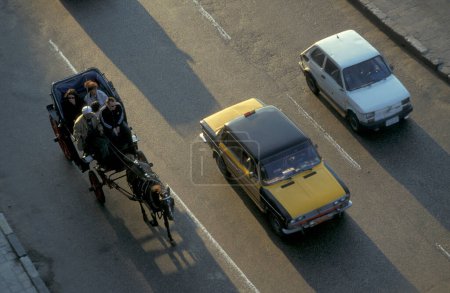 Téléchargez les photos : Voitures et une charrette à cheval à la route al Corniche dans la ville d'Alexandrie sur la mer Méditerranée en Egypte en Afrique du Nord. Égypte, Alexandrie, mars 2000 - en image libre de droit
