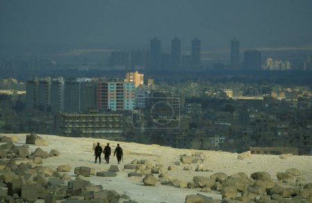 Téléchargez les photos : Hommes de sécurité en face de la vue de la ville Le Caire des Pyramindes dans la capitale de l'Egypte en Afrique du Nord. Égypte, Le Caire, mars 2000 - en image libre de droit