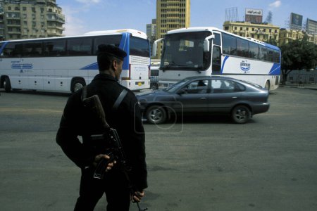 Téléchargez les photos : Police et bus touristique en face du Musée égyptien ancien dans la vieille ville du Caire la capitale de l'Egypte en Afrique du Nord. Égypte, Le Caire, mars 2000 - en image libre de droit