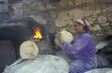 Foto de Una mujer hornea un pan en la ciudad y un oasis de Farafra en el desierto libio o en el desierto de Egipto en el norte de África. Egipto, Farafra, marzo de 2000 - Imagen libre de derechos