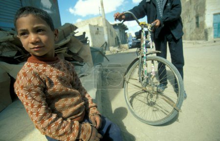 Téléchargez les photos : Personnes à bicyclette dans la ville et l'oasis de Farafra dans le désert libyen ou le désert d'Egypte en Afrique du Nord. Égypte, Farafra, mars 2000 - en image libre de droit