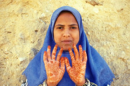 Téléchargez les photos : Une fille avec peinture au henné à la main dans la ville et l'oasis de Farafra dans le désert libyen ou le désert d'Egypte en Afrique du Nord. Égypte, Farafra, mars 2000 - en image libre de droit