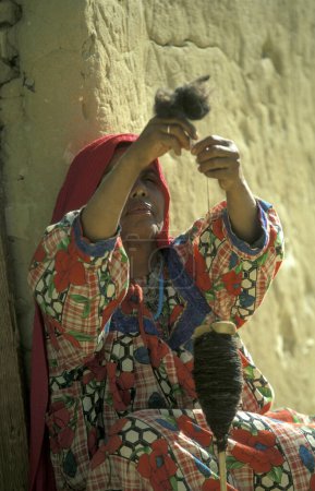 Téléchargez les photos : Femmes au travail pour filer la laine dans la ville et l'oasis de Farafra dans le désert libyen ou le désert d'Egypte en Afrique du Nord. Égypte, Farafra, mars 2000 - en image libre de droit