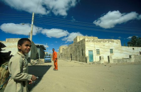 Téléchargez les photos : Un garçon dans la ville et l'oasis de Farafra en Libye ou dans le désert d'Egypte en Afrique du Nord. Égypte, Farafra, mars 2000 - en image libre de droit