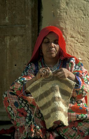 Téléchargez les photos : Femmes au travail pour faire un pull-over dans la ville et l'oasis de Farafra dans le désert libyen ou le désert d'Egypte en Afrique du Nord. Égypte, Farafra, mars 2000 - en image libre de droit