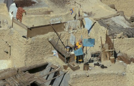 Téléchargez les photos : Une femme sur un toit dans la ville et l'oasis de Farafra dans le désert libyen ou le désert d'Egypte en Afrique du Nord. Égypte, Farafra, mars 2000 - en image libre de droit
