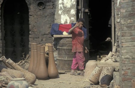 Téléchargez les photos : Un enfant travaille dans une usine de poterie dans la vieille ville du Caire la capitale de l'Egypte en Afrique du Nord. Égypte, Le Caire, mars 2000 - en image libre de droit