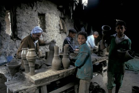 Téléchargez les photos : Hommes travailleurs dans une usine de poterie dans la vieille ville du Caire la capitale de l'Egypte en Afrique du Nord. Égypte, Le Caire, mars 2000 - en image libre de droit