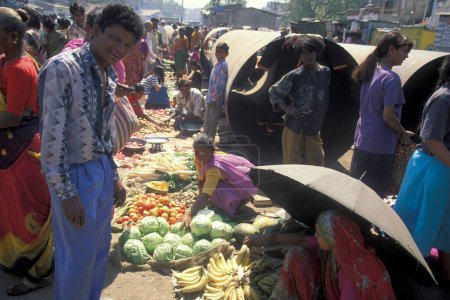 Foto de Personas frente a una gran tubería de agua en el mercado de alimentos en la ciudad de Surat en la provincia de Gujarat en la India. India, Gujarat, abril de 1998 - Imagen libre de derechos