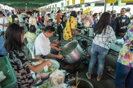 Téléchargez les photos : Les gens profitent gratuitement de la nourriture thaïlandaise lors d'une cérémonie du temple au Wat Hua Hin dans la ville de Hua Hin dans la province de Prachuap Khiri Khan en Thaïlande, Thaïlande, Hua Hin, Décembre, 2023 - en image libre de droit