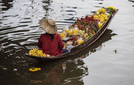 Photo for A women sales fruits on her woodboat at Damnoen Saduak Floating market in Province of Ratchaburi in Thailand,  Thailand, Ratchaburi, November, 12, 2023 - Royalty Free Image
