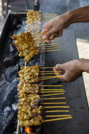 Photo for Chicken Satay grill at Market street in the city centre of Mueang Chonburi City at Province of Chonburi in Thailand.  Thailand, Chonburi, October, 29, 2023 - Royalty Free Image