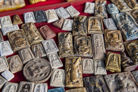 Thailand, Ubon Ratchathani - 25. November 2023: Amulette auf der Theke des thailändischen Amulettenmarktes im Stadtzentrum von Udon Ratchathani und der Provinz Ubon Ratchathani in Thailand.