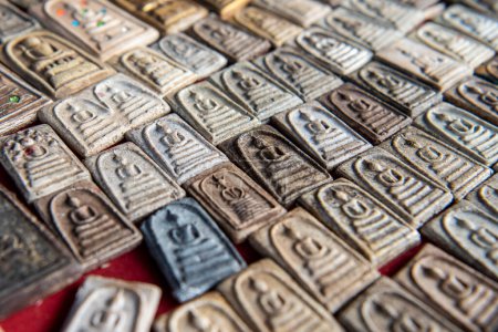 Téléchargez les photos : Thaïlande, Ubon Ratchathani - 25 novembre 2023 : Amulettes sur le comptoir du marché thaïlandais des amulettes dans le centre-ville d'Udon Ratchathani et la province d'Ubon Ratchathani en Thaïlande. - en image libre de droit