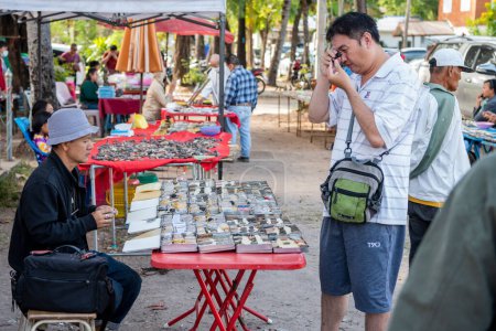 Téléchargez les photos : Thaïlande, Ubon Ratchathani - 25 novembre 2023 : Sélection d'amulettes sur le marché thaïlandais des amulettes dans le centre-ville d'Udon Ratchathani et la province d'Ubon Ratchathani en Thaïlande. - en image libre de droit