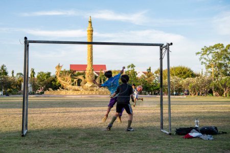 Photo for Thailand, Ubon Ratchathani - November 22, 2023: Kids playing soccer in front of Thung Sri Mueang Monument in city Udon Ratchathani and Province Ubon Ratchathani in Thailand. - Royalty Free Image