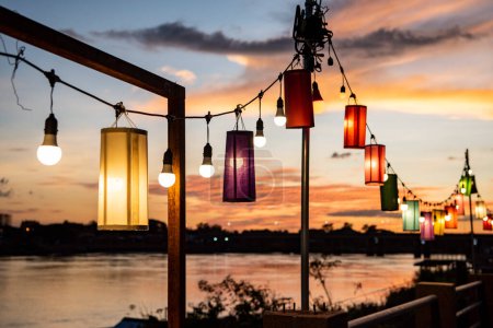 Photo for Restaurant lanterns at sunset on Mun River in city centre of Udon Ratchathani and Province Ubon Ratchathani in Thailand.  Thailand, Ubon Ratchathani, November 23, 2023 - Royalty Free Image