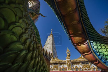Foto de Tailandia, Ubon Ratchathani - 24 de noviembre de 2023: Serpiente arcoiris alrededor de Sri Maha Pho Chedi de Wat Phra That Nong Bua Temple en el centro de Ubon Ratchathani y la provincia Ubon Ratchathani en Tailandia. - Imagen libre de derechos