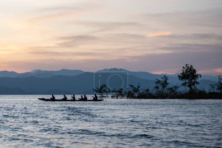Foto de Equipo de remo Longboat en el entrenamiento en la presa del lago Kaeng Krachan en el Parque Nacional Kaeng Krachan en la provincia de Phetchaburi en Tailandia. Tailandia, Phetchaburi, 19 de noviembre de 2023 - Imagen libre de derechos