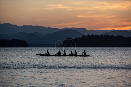 Foto de Equipo de remo Longboat en el entrenamiento en la presa del lago Kaeng Krachan en el Parque Nacional Kaeng Krachan en la provincia de Phetchaburi en Tailandia. Tailandia, Phetchaburi, 19 de noviembre de 2023 - Imagen libre de derechos