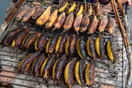 Téléchargez les photos : Griller la banane dans une Marketstreet dans la ville chinoise de Bangkok en Thaïlande. Thaïlande, Bangkok, 8 novembre 2023 - en image libre de droit