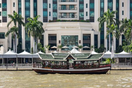 Téléchargez les photos : Un bateau à l'Hôtel Peninsula sur la rivière Chao Phraya dans la ville de Bangkok en Thaïlande. Thaïlande, Bangkok, 5 décembre 2023 - en image libre de droit