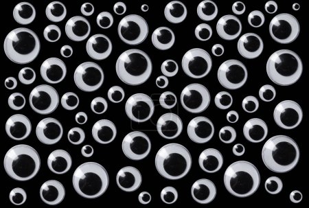 Googly Eyes sind kleine Kunststoff-Bastelzubehör verwendet werden, um Augäpfel isoliert auf schwarzem Hintergrund imitieren.