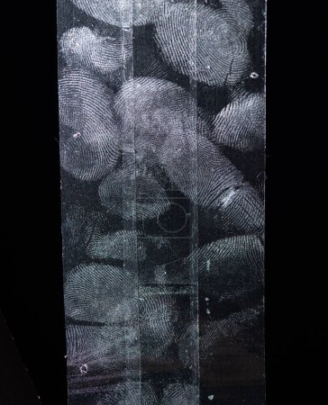 Foto de Tinte de dedos sobre cinta adhesiva transparente o tiras aisladas sobre fondo negro - Imagen libre de derechos