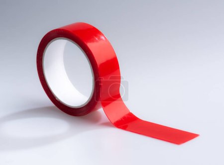 Doppelseitiges Klebeband in roter Farbe auf weißem Hintergrund