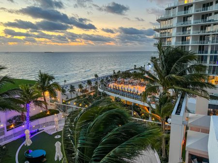 Foto de Fort Lauderdale, FL USA - 19 de diciembre de 2022: Una vista aérea de la terraza al aire libre y la piscina en el Conrad Hilton Hotel en Fort Lauderdale, Florida al atardecer. - Imagen libre de derechos