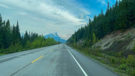 Driving on the mountainous stunningly beautiful Icefields Parkway in Jasper and Banff National Parks in Canada on a sunny spring day.