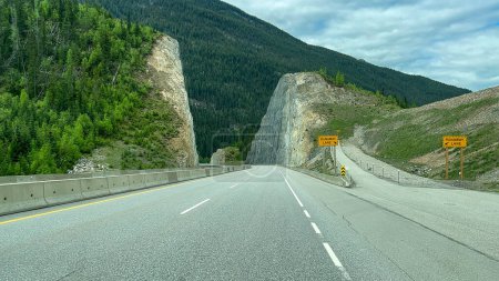 La vista panorámica mientras conduce la autopista Trans Canada Highway cerca de los parques nacionales Yoho, Kootenay, Banff y Jasper en Canadá en un día nublado de primavera.