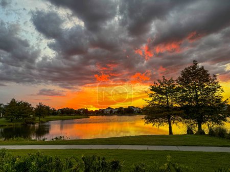Sonnenuntergang in einem Viertel, das sich auf einem See im Laureate Park Lake Nona Orlando, Florida, spiegelt..