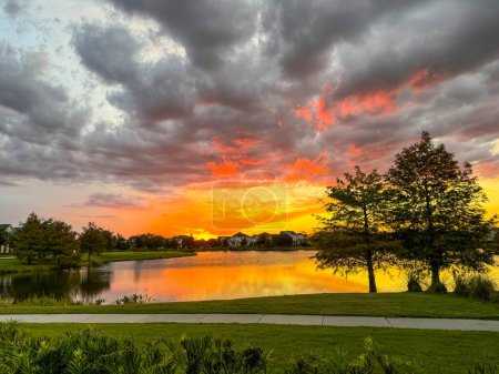Puesta de sol en un barrio que refleja en un lago en Laureate Park Lake Nona Orlando, Florida..