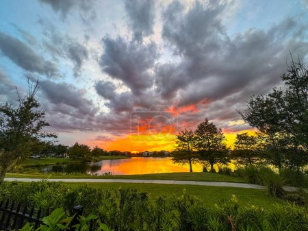Coucher de soleil dans un quartier qui se reflète sur un lac à Laureate Park Lac Nona Orlando, Floride..