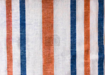 Foto de Homespun towel. Ukrainian rushnyk is decorated with red stripes and fringe. It is rolled. old cloth. Homespun towel background. Homespun towel - Imagen libre de derechos